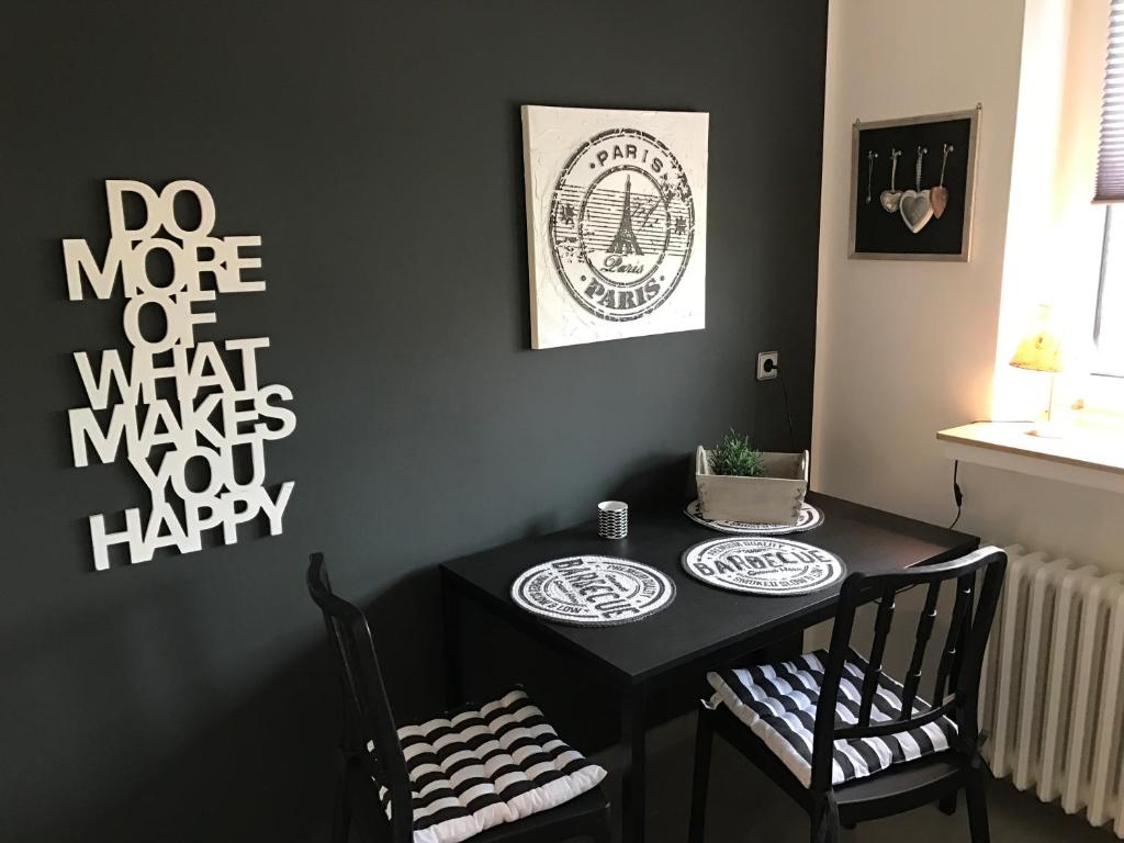 une table noire avec deux chaises dans une pièce dans l'établissement Le Flair Appartement Mülheim, à Mülheim