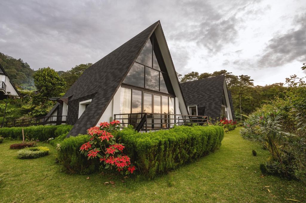 a house with a black roof and some plants at Buyan Lakeside Villas in Bedugul