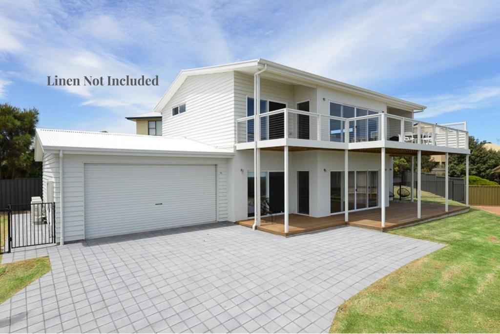 a large white house with a garage at Magnificent Boomer Beach in Port Elliot