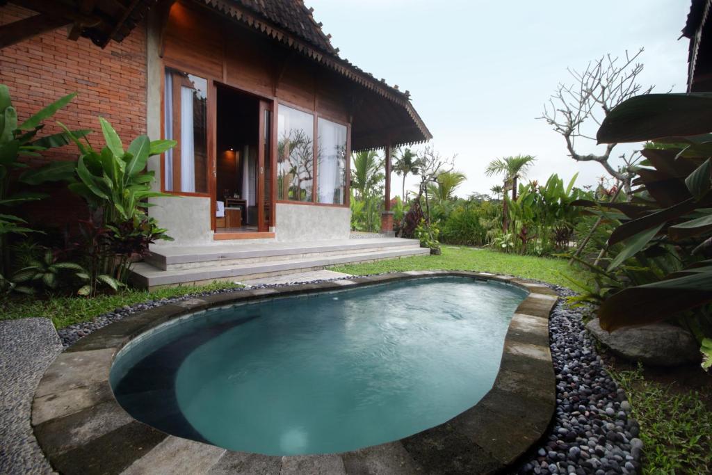 a small swimming pool in front of a house at Pondok Kumpi ubud in Ubud