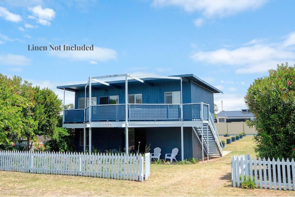 a blue house with a white fence in front of it at The Blue Bunyip - 3 Bunyip St , Goolwa South in Goolwa South