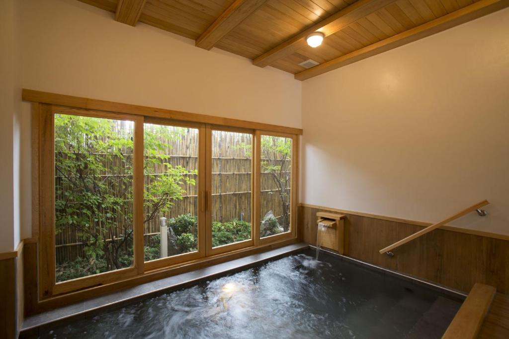 an indoor pool in a room with a large window at Hinoki Hotel - ONSEN Chiang Mai in Chiang Mai