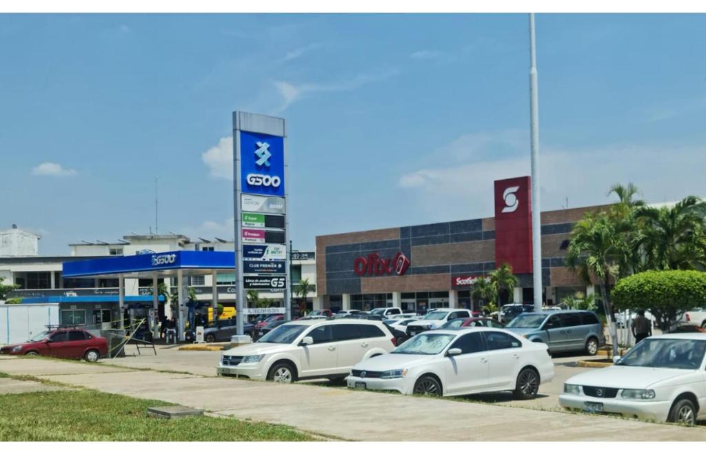 a parking lot with cars parked in front of a store at Depa YAZI in Villahermosa