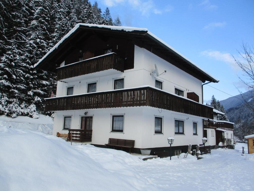 ein großes weißes Gebäude mit Balkon im Schnee in der Unterkunft Adlerhorst in Sellrain