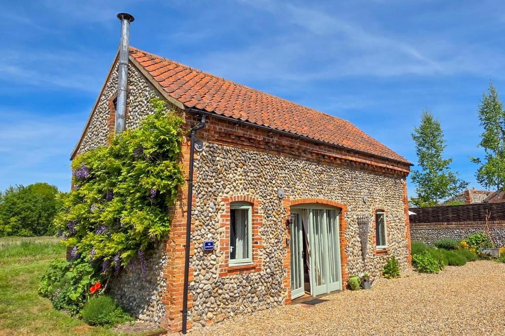 a small brick house with ivy growing on it at 2 Bed in Field Dalling oc-1643 in Saxlingham