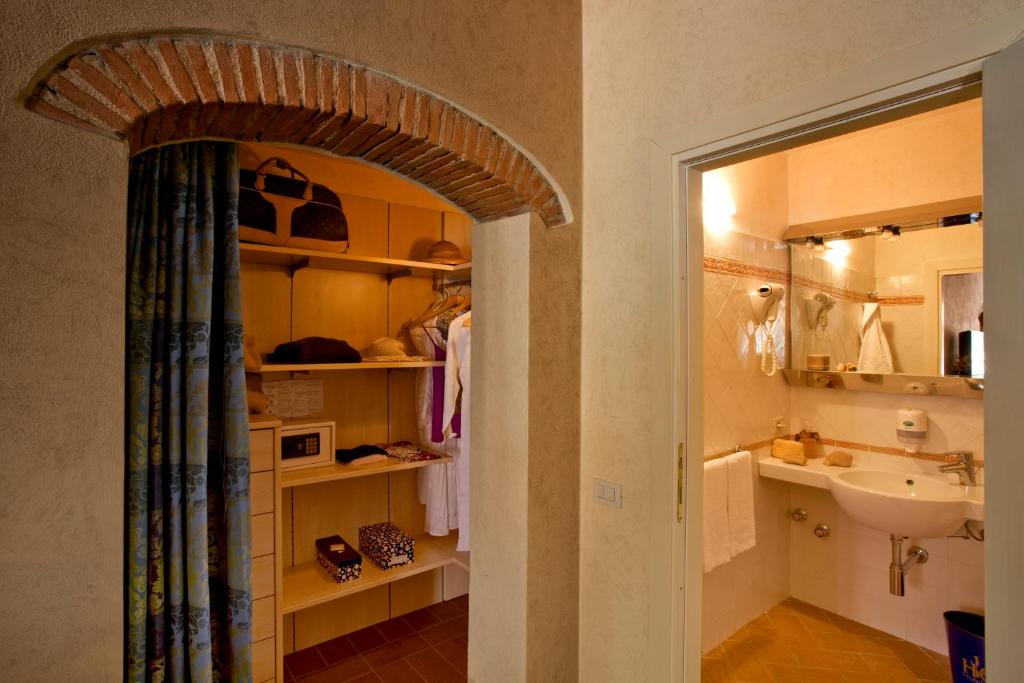 ポモンテにあるHotel Coralloの洗面台、トイレ、鏡のあるバスルーム