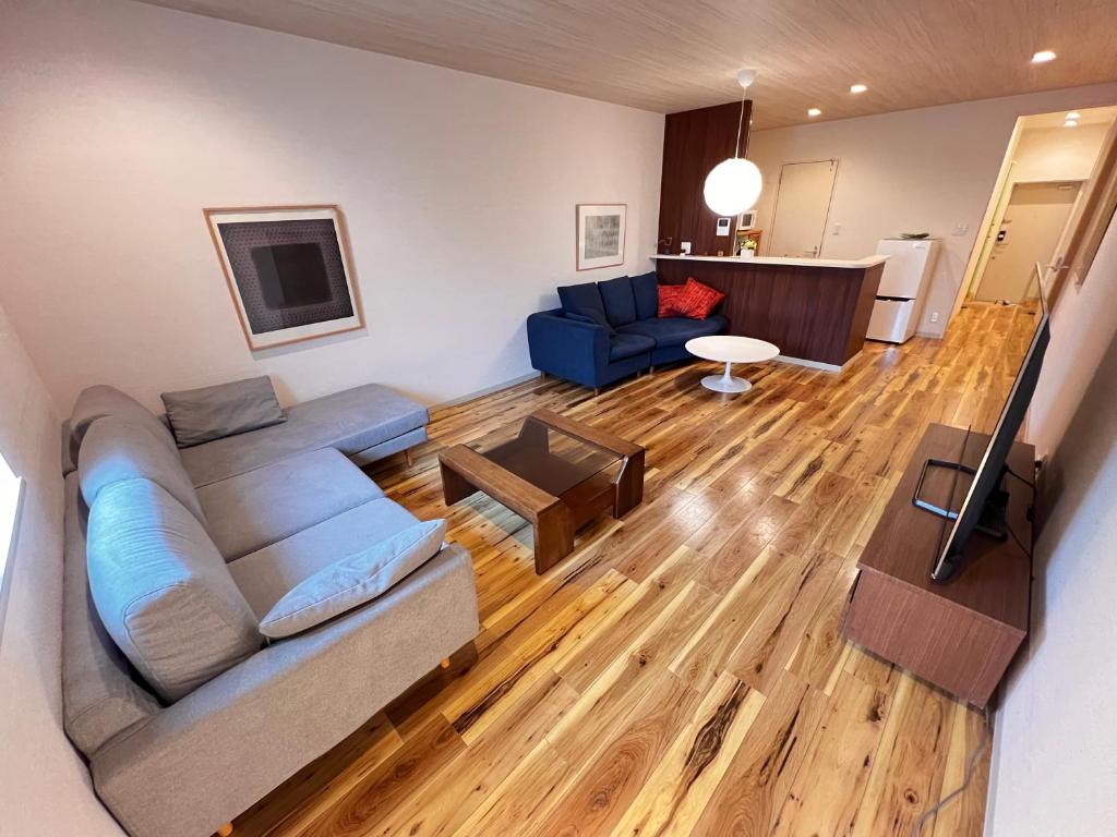 a living room with a couch and a table at 内町3階 高松中心地 広いメゾネット貸切 2ベッドルーム 最大4名 in Takamatsu