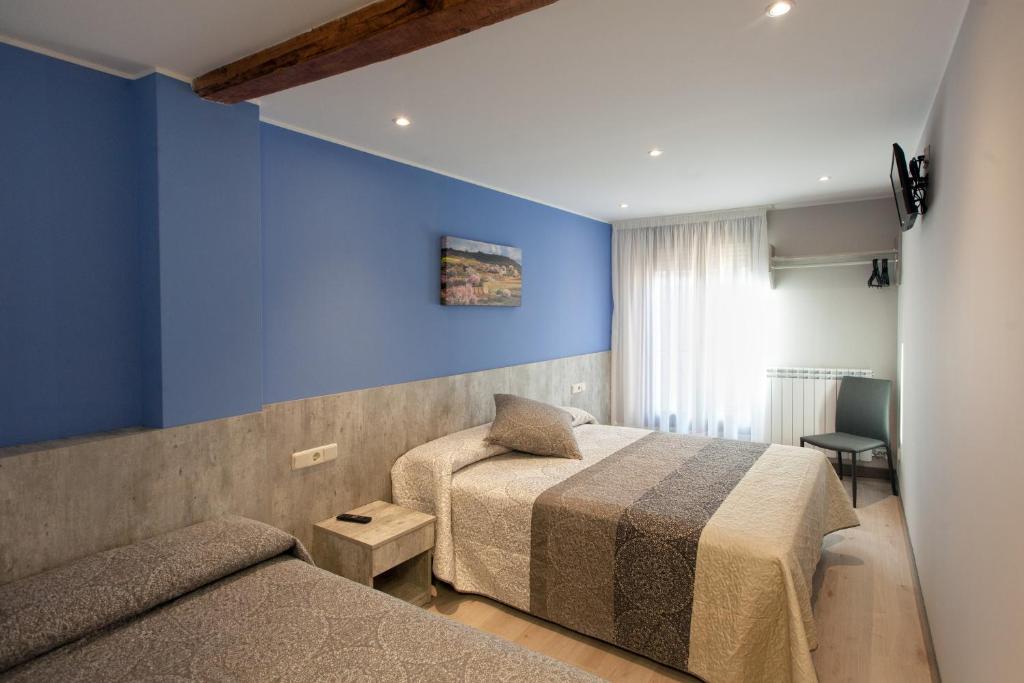 um quarto com 2 camas e uma parede azul em Pensión San Lorenzo em Nájera