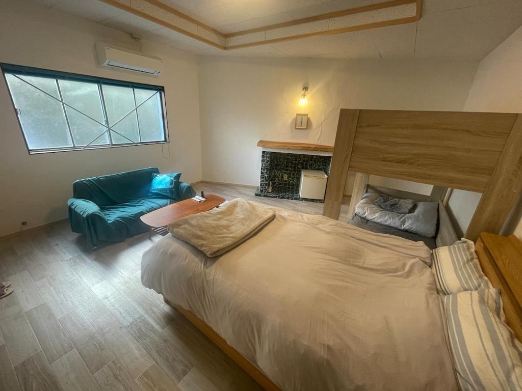 a bedroom with a large bed and a blue couch at Old Sunny Garage in Tosashimizu