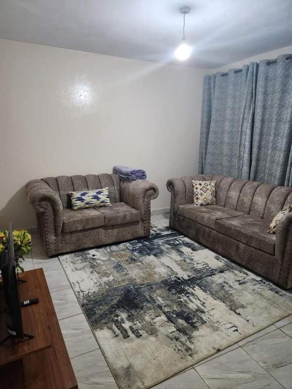 a living room with a couch and a rug at Muthiga Springs in Kikuyu