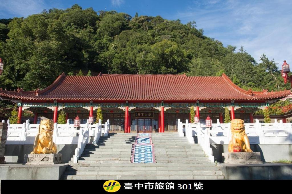 a chinese temple with two statues in front of it at Lishan Guest House in P'ing-yen-shan