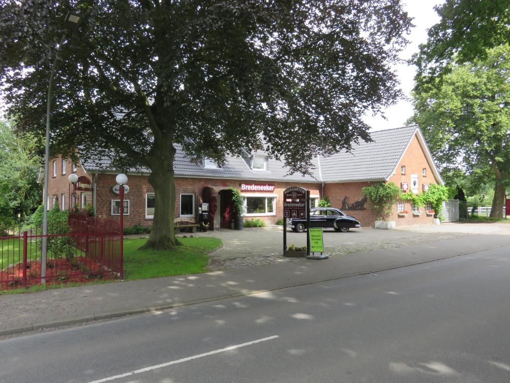 ein Gebäude an der Seite einer Straße mit einem Baum in der Unterkunft Bredeneeker Gasthaus in Rastorf