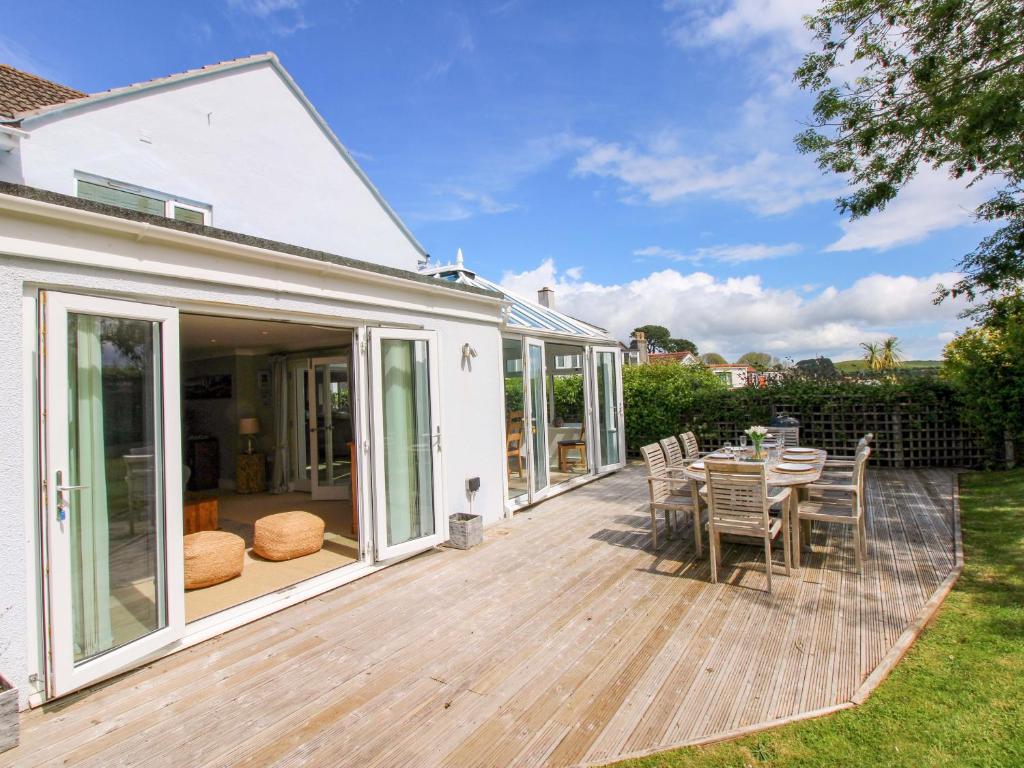eine Terrasse mit Tisch und Stühlen auf einem Deck in der Unterkunft Welsummer in Salcombe