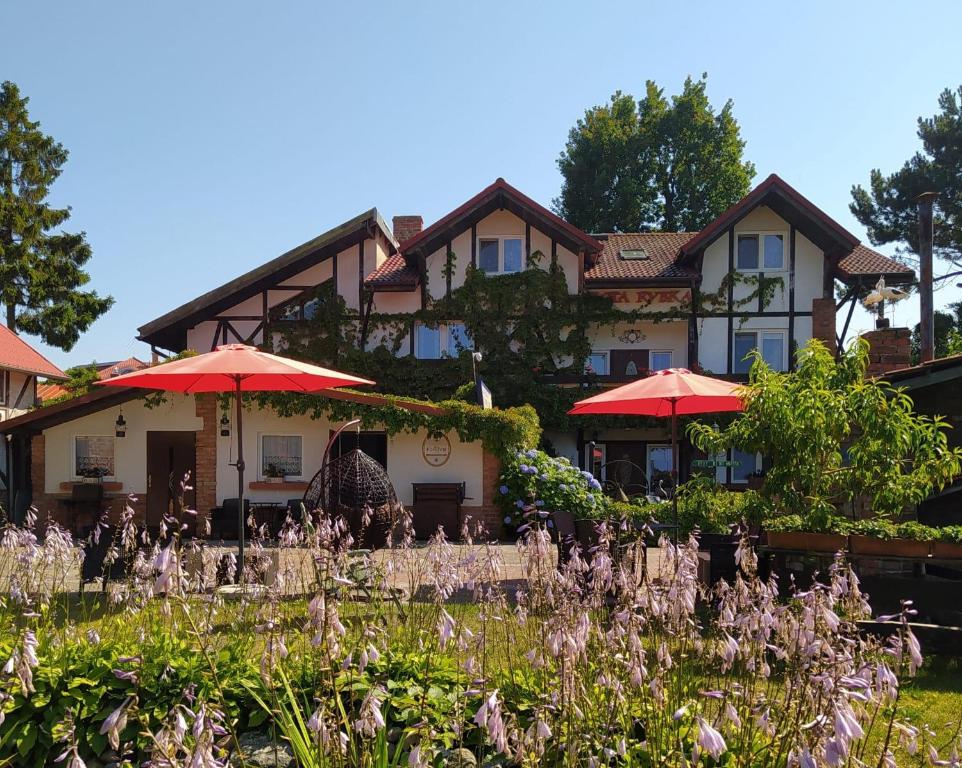 a house with red umbrellas in front of it at Złota Rybka in Rowy