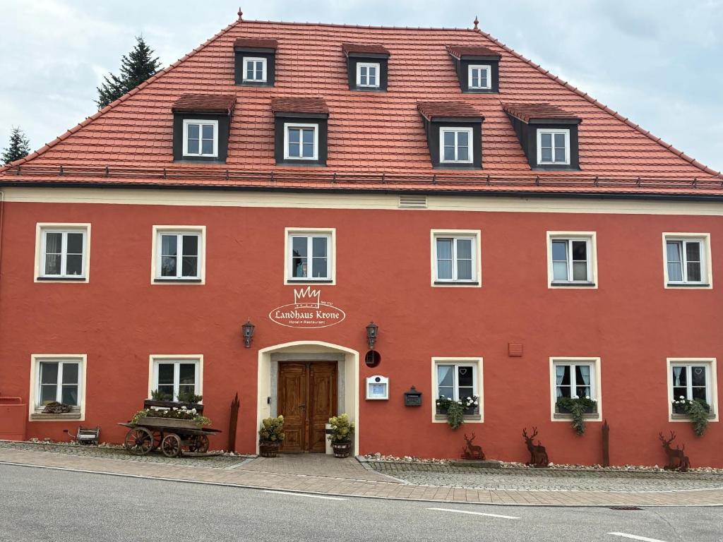 ein großes rotes Gebäude mit rotem Dach in der Unterkunft Landhaus Krone in Steinach