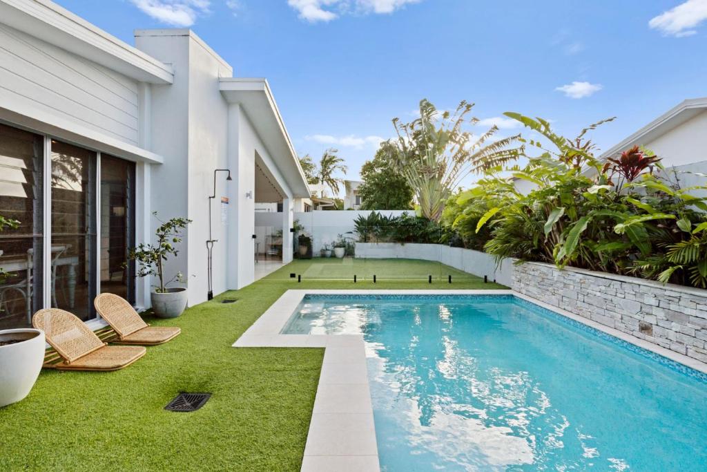 a swimming pool in the backyard of a house at Tallows Coastal Retreat in Kingscliff