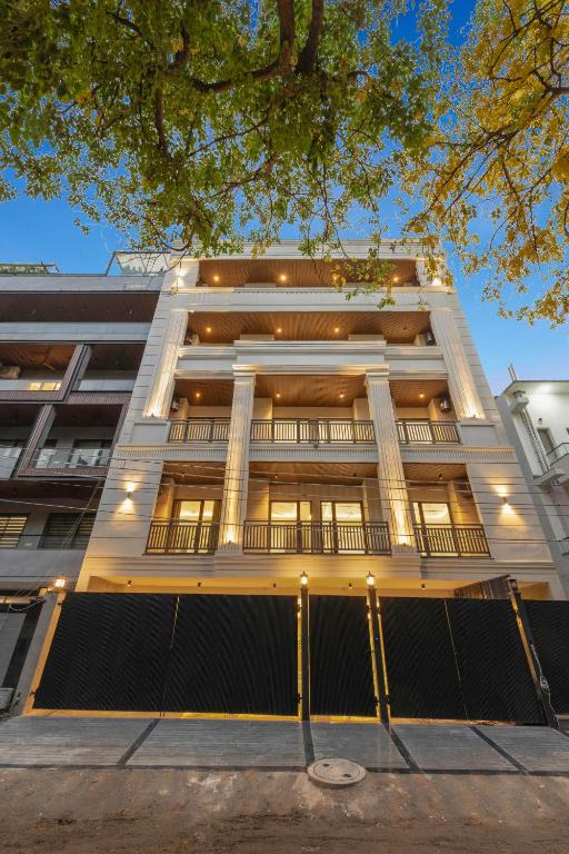 a large white building with columns at Alaya Stays Luxora Suites, Golf Course Rd near galleria in Gurgaon