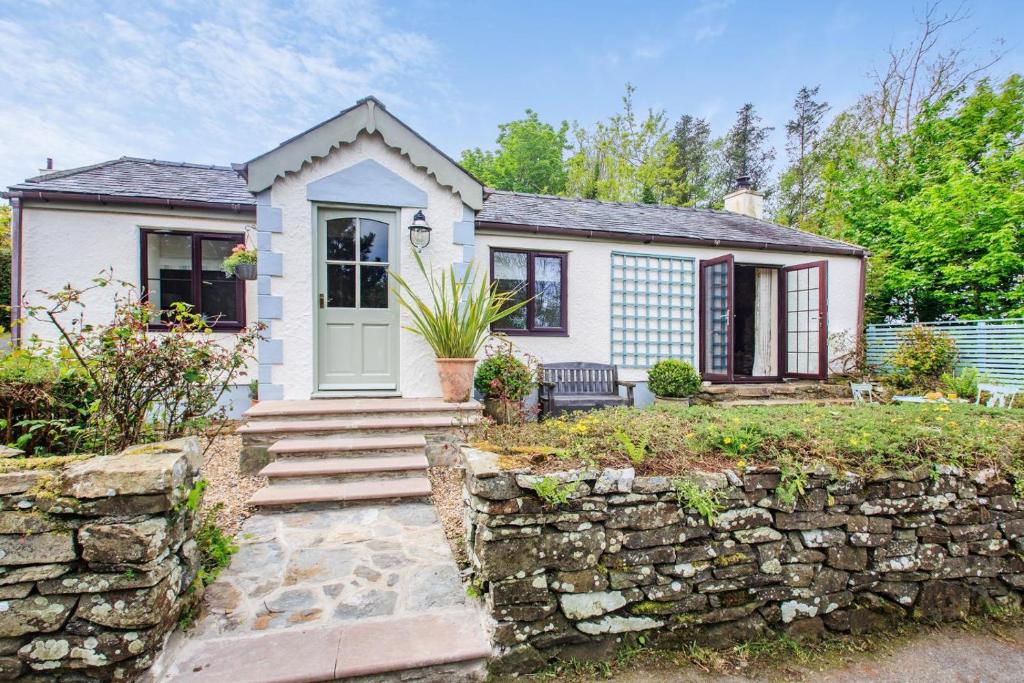 a stone wall in front of a house at 2 Bed in Carmel oc-wai210 in Llanerchymedd