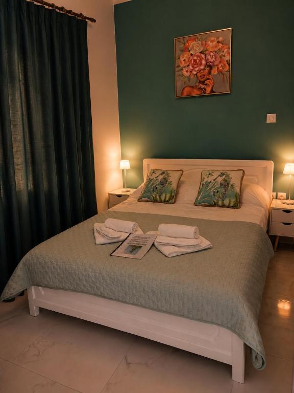 a bedroom with a bed with two towels on it at MANI HOLIDAYS Rooms in Neo Itilo