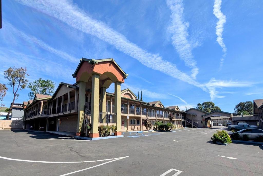 an empty parking lot in front of a building at Olive Tree Inn & Suites, a Howard Johnson by Wyndham in San Luis Obispo
