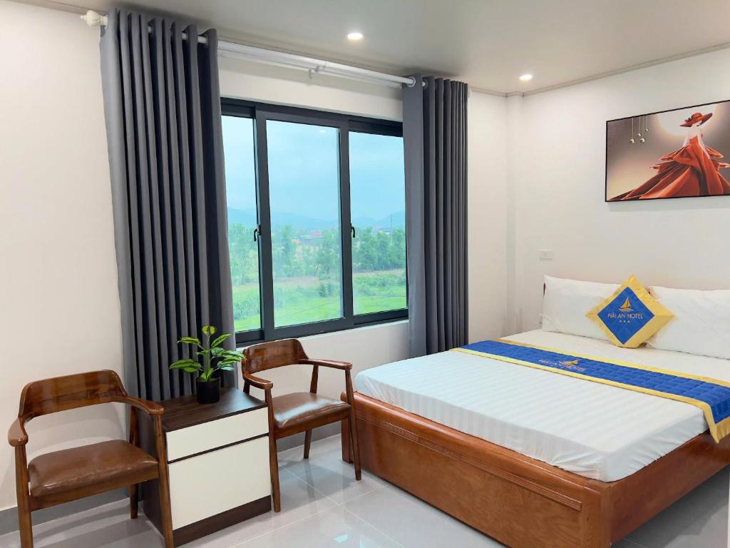 a bedroom with a bed and a chair and a window at Hải An Hotel in Nhượng Bạn