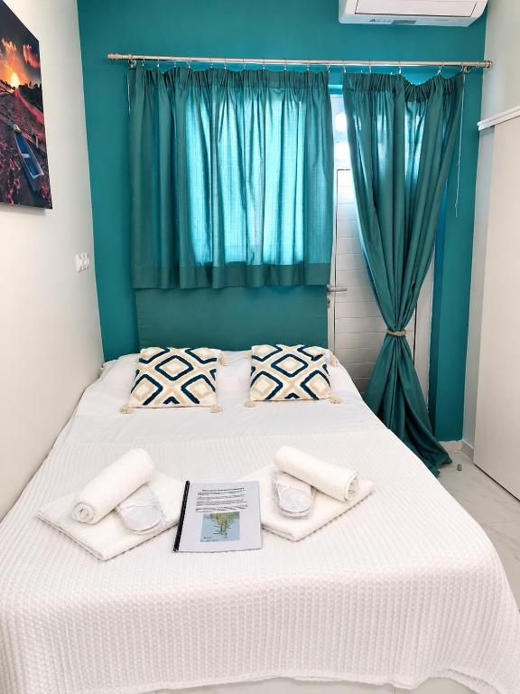 a bedroom with a bed with two towels on it at MANI HOLIDAYS Rooms in Neo Itilo
