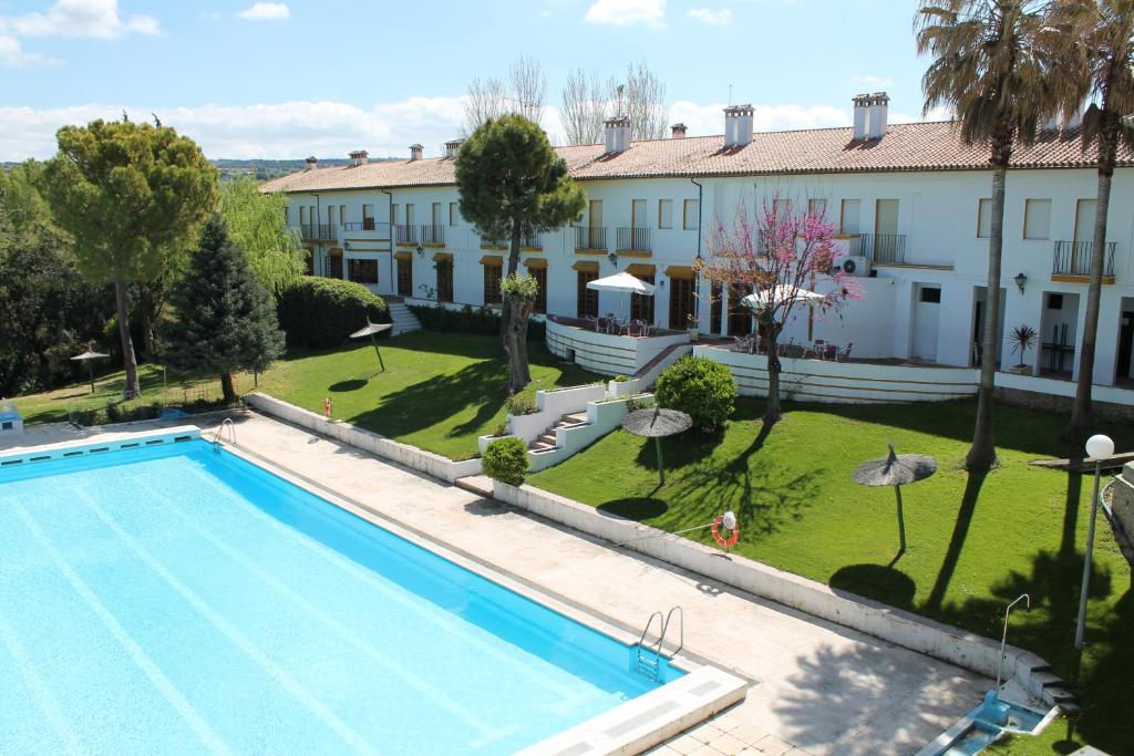 
a large swimming pool in front of a house at Tugasa Hotel El Almendral in Setenil

