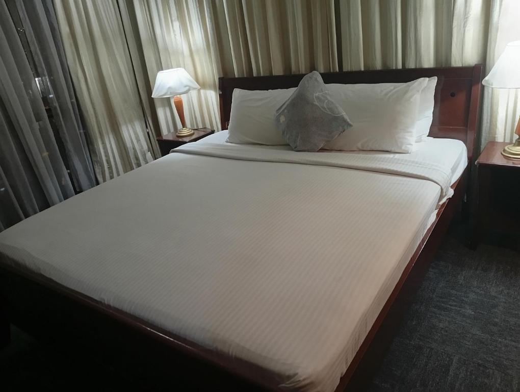 a bedroom with a large bed with white sheets and pillows at Imperial resident time Square KL in Kuala Lumpur