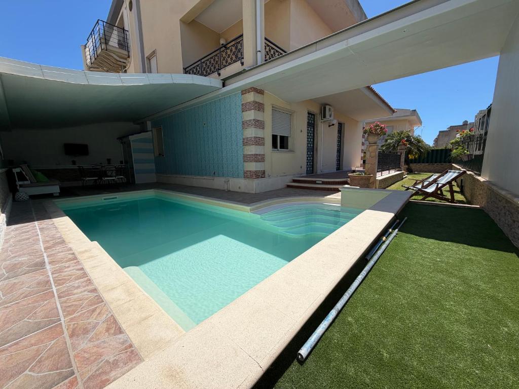 a swimming pool in the backyard of a house at Villa Aurea in Avola