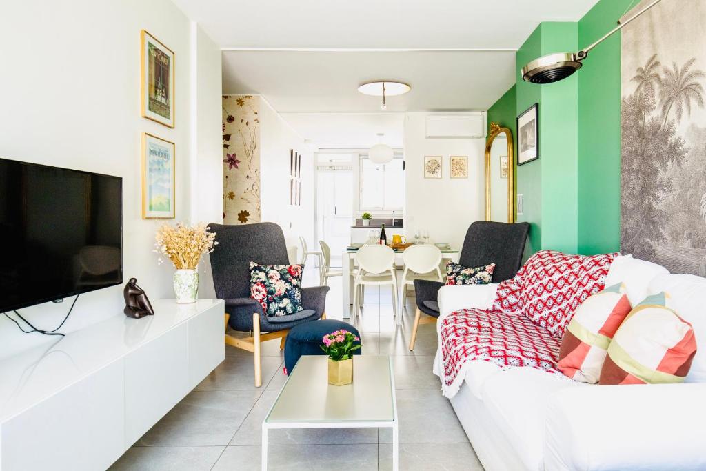 a living room with a white couch and a green wall at 2 ch, climatisé, parking, localisation premium in Lyon