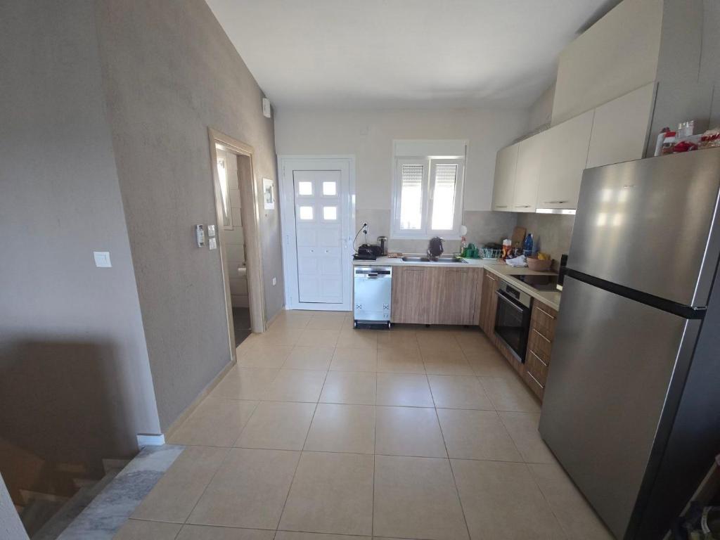 a kitchen with a refrigerator and a counter top at Vlad's Apartments in Larisa