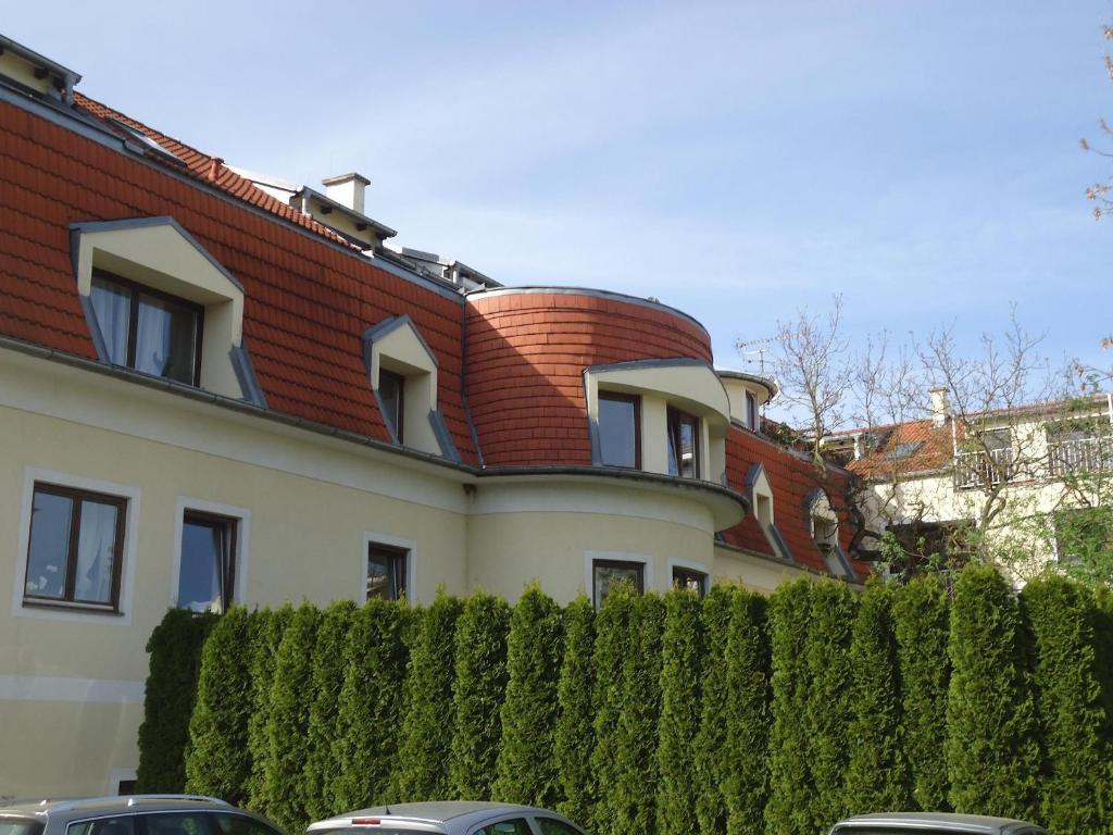 ein Haus mit rotem Dach und einem Zaun in der Unterkunft Ferienwohnung Madlene 2 in Gablitz