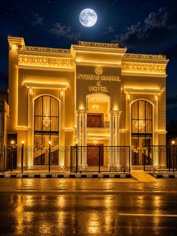 a building at night with a full moon at Hyders Mahal & Hotel in Thanjāvūr