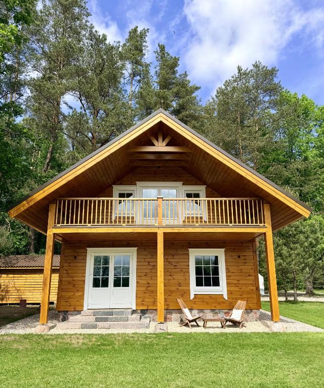 a log cabin with a porch and a deck at Lake Lodge Labanoras in Šnioriškės