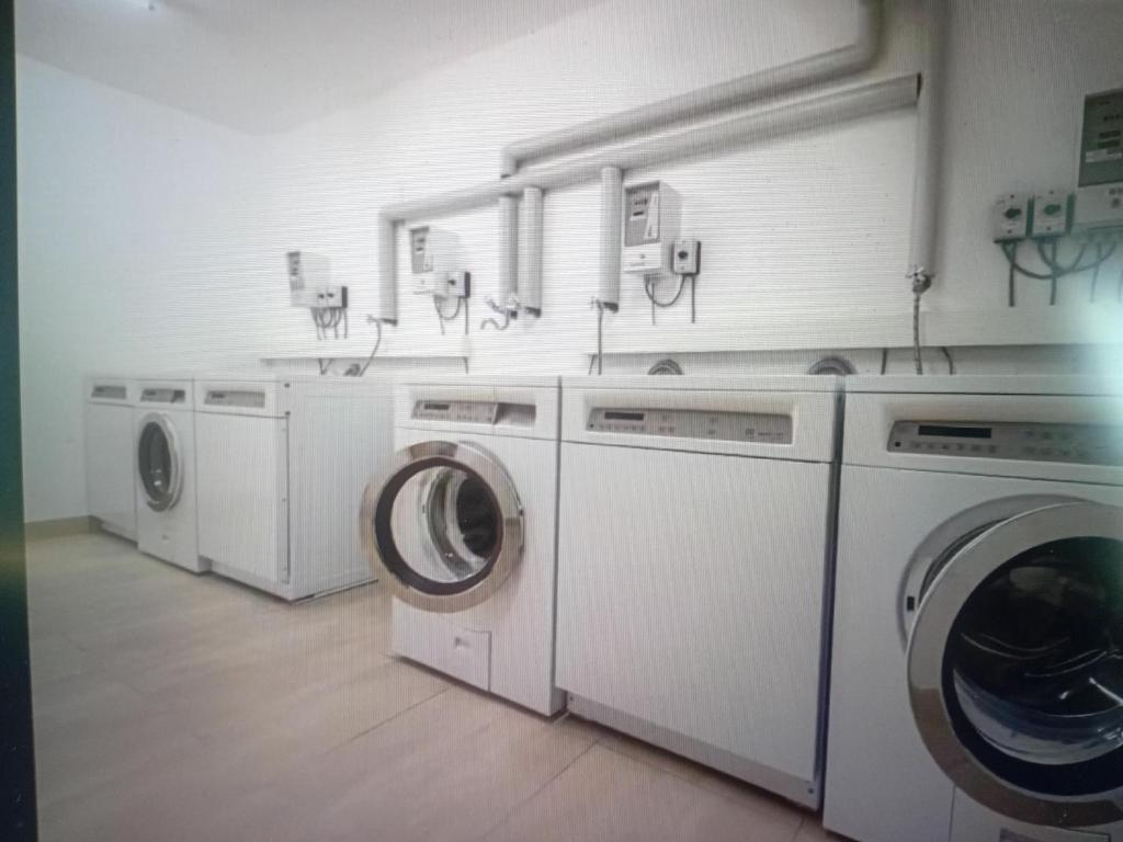 a laundry room with three washing machines and sinks at Saas Grund MiK Home in Saas-Grund