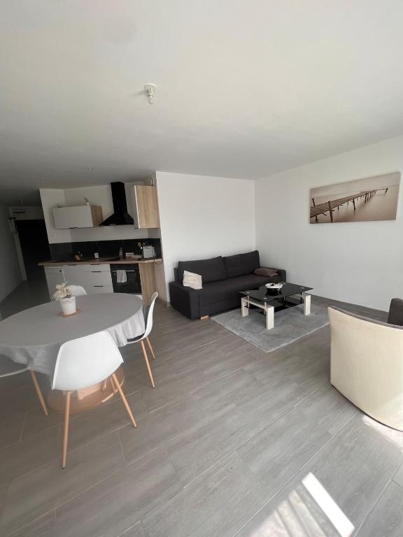 a living room with a table and a couch at Langueux Apartment in Langueux