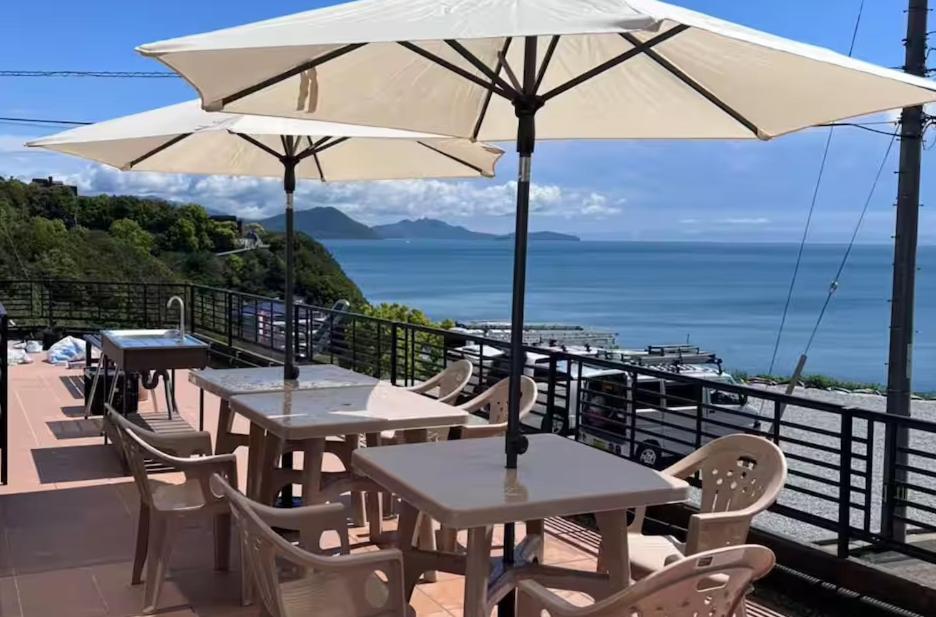 a group of tables with umbrellas on a balcony at Sunrise Resort Aji in Takamatsu