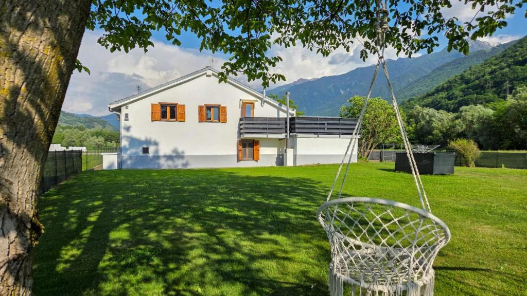 a swing hanging from a tree in front of a house at C'Amunin Casa Vacanze in Chiuro