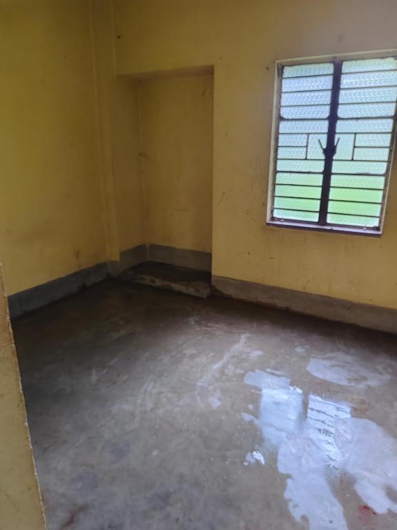 an empty room with a window and a concrete floor at Pranusree Holiday Home in kolkata