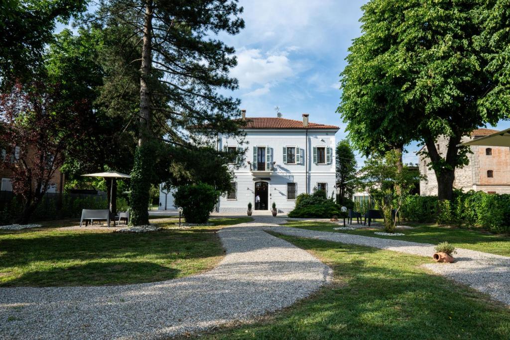 a driveway leading to a white house at Le Dolci Dimore in Virgilio