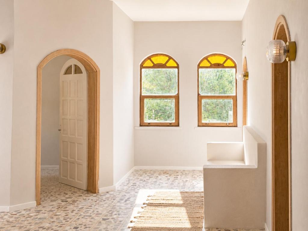 a hallway with a white door and two windows at Sea Salt Inn in Kemer