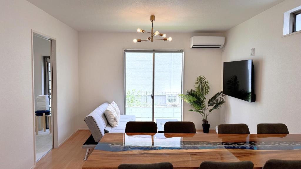 ein Wohnzimmer mit einem Tisch und einem Sofa in der Unterkunft Rect YOFUKE in Nago