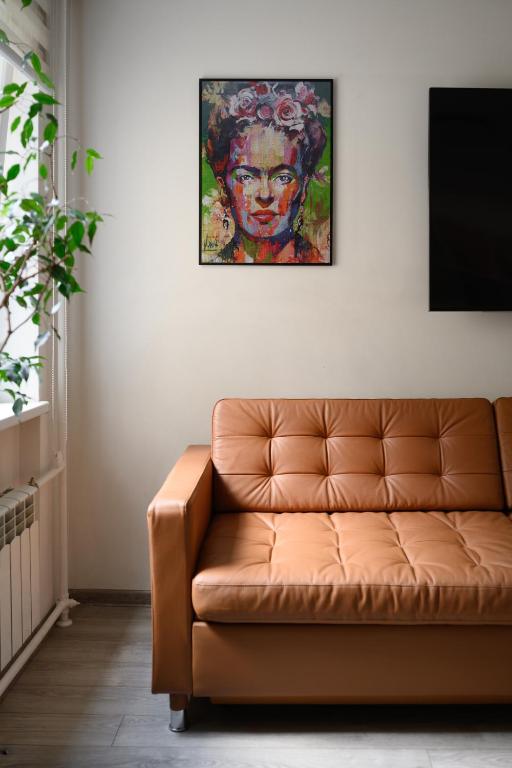 a couch in a living room with a painting on the wall at Algirdo Apartments, Self Check-in, Free Private Parking in Vilnius