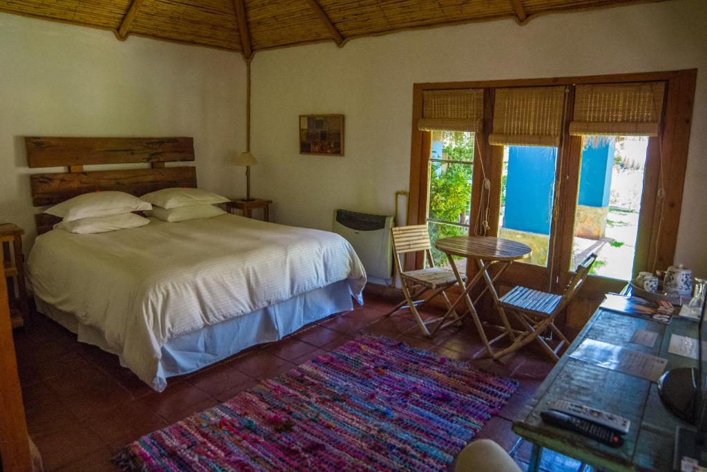 a bedroom with a bed and a table and chairs at Refugio Misterios del Elqui in Pisco Elqui