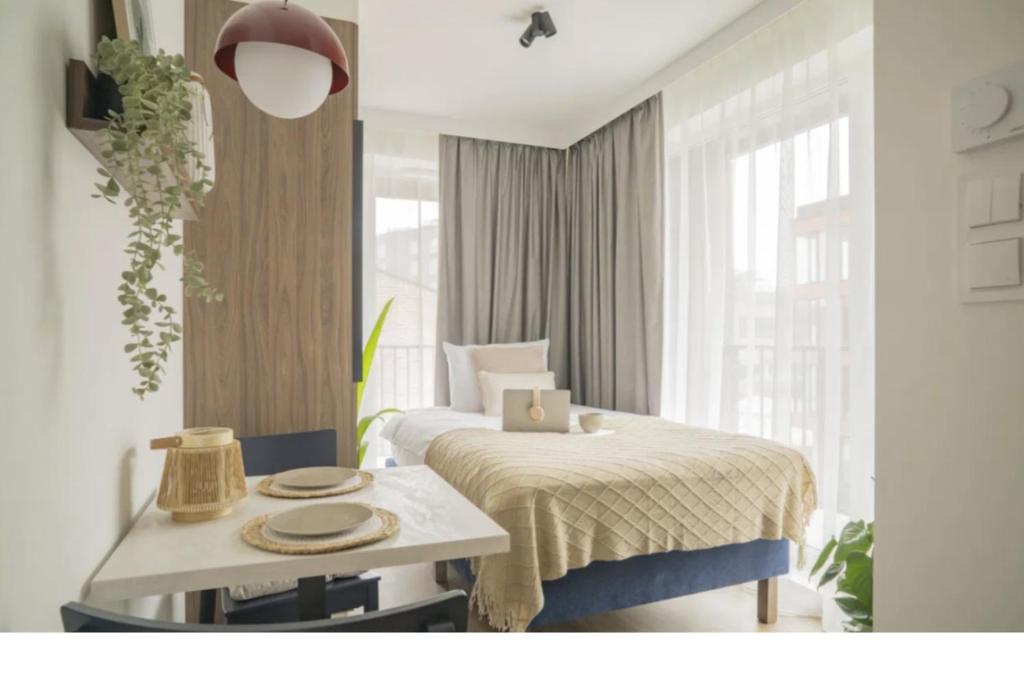 a hotel room with a bed and a table with plates on it at Noli Gdansk Wrzeszcz in Gdańsk