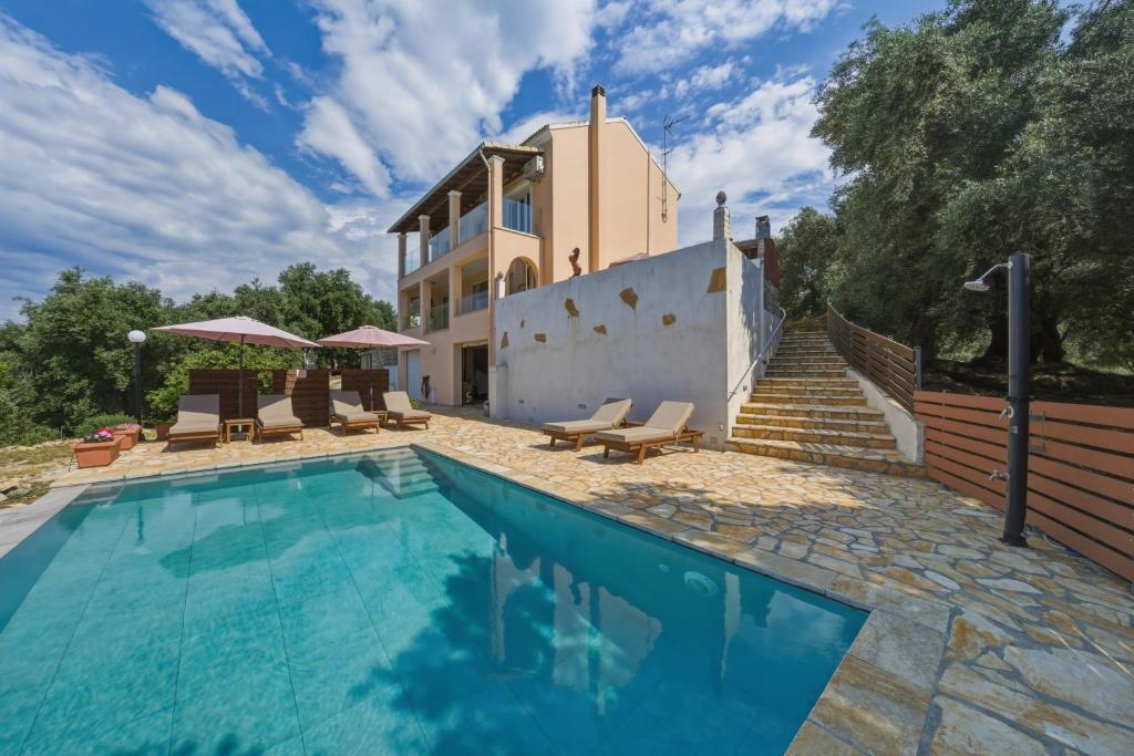 a villa with a swimming pool in front of a house at Villa Sarakinos in Kriniás