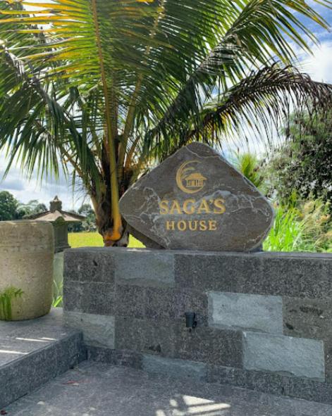 a sign for aazacs house sitting on a wall at Cozzy Sagas House Tabanan in Perean
