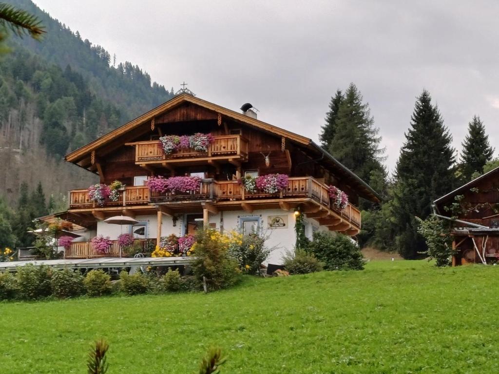 a house with flowers on the balconies of it at Chalets Dolomiti living in Vergein