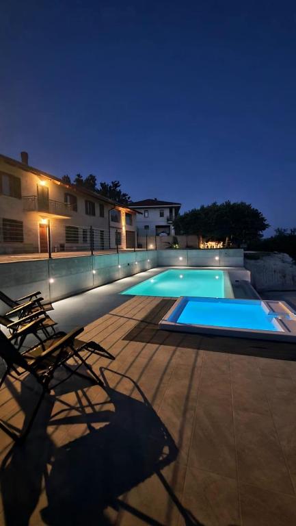 a swimming pool at night with a chair and a building at CÁ d ANGELO in Canove