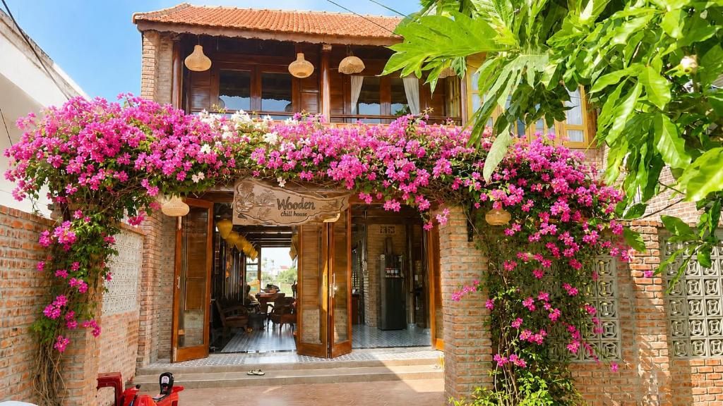 a brick building with pink flowers on it at Wooden chill house in Hoi An